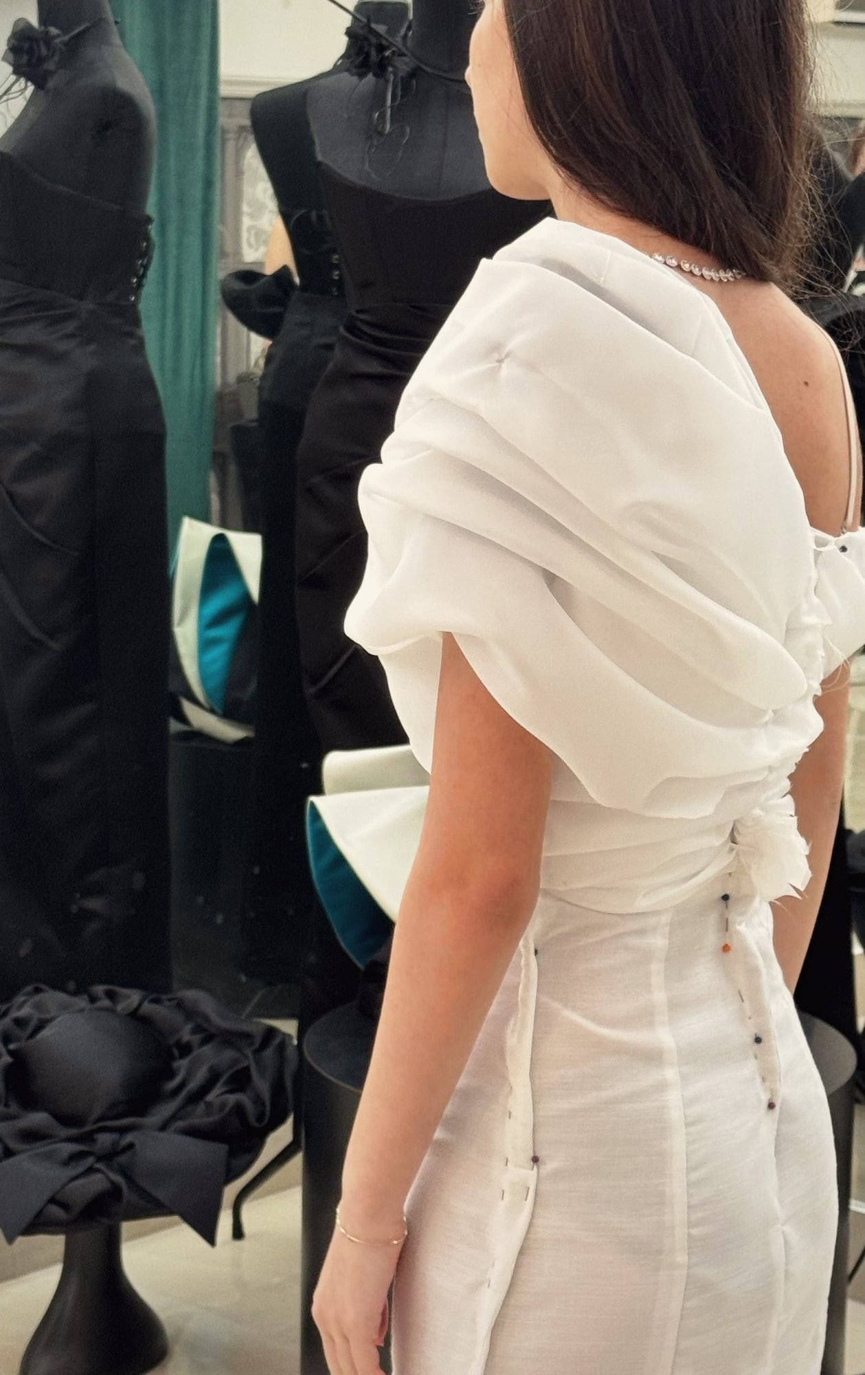 Abito bianco drappeggiato, in prova